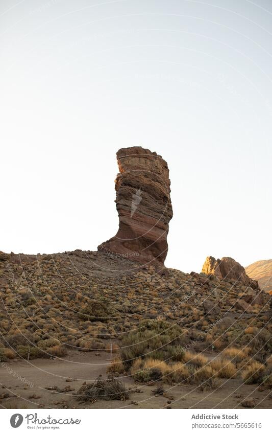 Majestätische Felsformation in einer ruhigen Landschaft Felsen Formation Ständer Klarer Himmel robust Gelände Vegetation imposant Gelassenheit natürlich