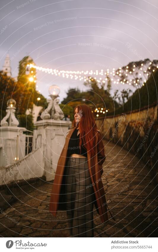 Elegante Frau im Herbst abends auf dem historischen Platz in Bogotá, Kolumbien rote Haare Eleganz Stil Mantel Hose schlendern Plaza beleuchtet funkeln Licht