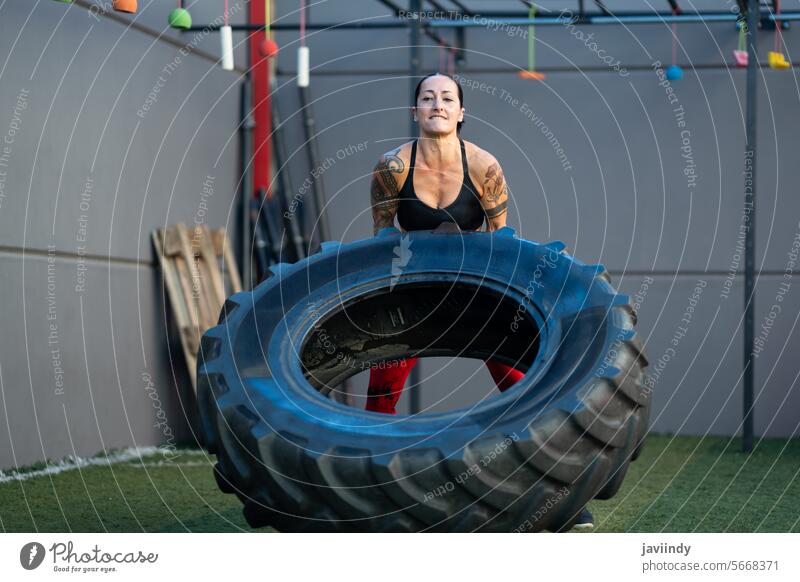 Starke reife Frau hebt ein Rad in einer Turnhalle frontal stark Heben Fitnessstudio Übung Stärke Training Gesundheit Wellness Erwachsener riesig Frauen Ausdauer