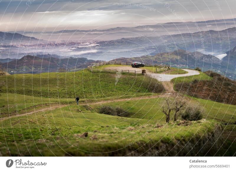 Wanderer auf einem Pfad, es ist Winter, der Himmel bewölkt, im Tal sieht man die Stadt Wiesen Tageslicht Natur Umwelt Landschaft Gipfel Berge u. Gebirge