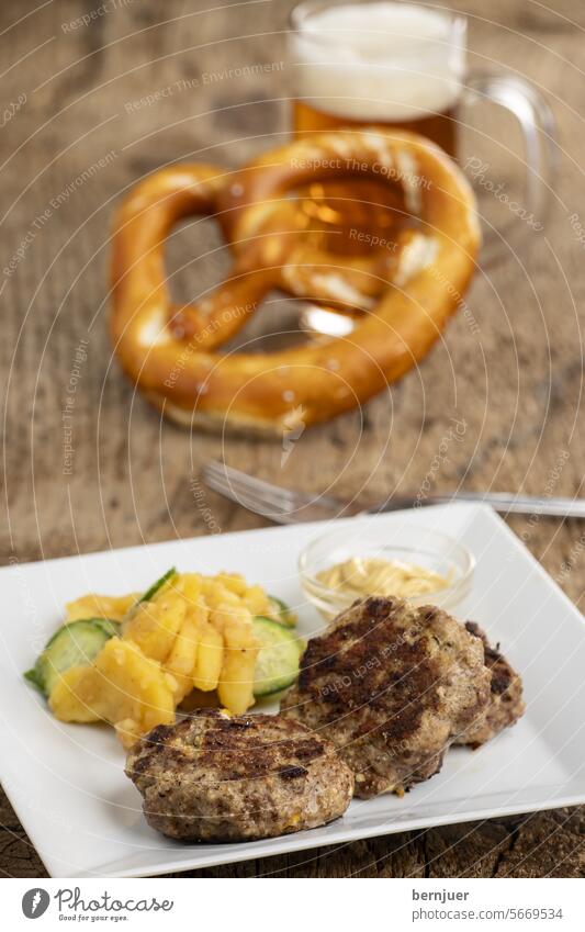 Bayerische Fleischpflanzerl mit Kartoffelsalat Frikadelle Holz Mahlzeit Essen Küche hausgemacht Gemüse Schweinefleisch Tomate Teller Portion Bulette Brett