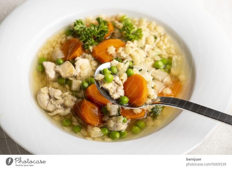 Hühnersuppe mit Brot im Überblick Hühnerbrühe Aufsicht Nudelsuppe Suppe Brühe Huhn Nudeln Stern Fleisch Erbse Karotte gesund Mahlzeit Essen Abendessen Küche