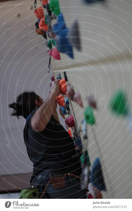 Aufstieg Klettern Kletterhallen drinnen Mann Dutt Männerdutt griffe Klettergriffe Kletterwand kletterer bunt sportlich Sport Bewegung Freizeit & Hobby Bouldern