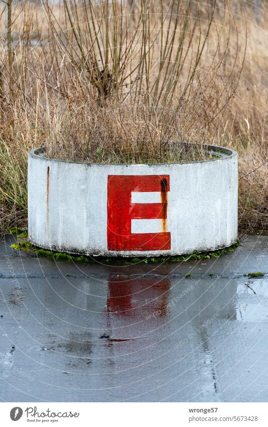 E wie … Buchstabe Regenwetter Regentag nass Betonring Straße Asphalt Spiegelung Reflexion & Spiegelung schlechtes Wetter grau Pfütze Außenaufnahme feucht