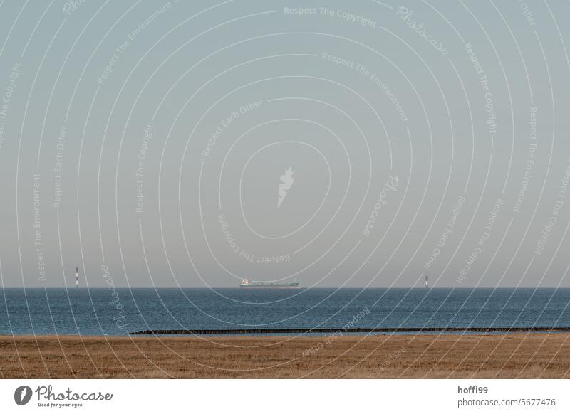 ruhige Panoramaaufnahme des Meeres mit Containerschiff und Schifffahrtszeichen am Horizont Nordseeküste Seehandel horizontal weite Sicht Himmel Weite Landschaft