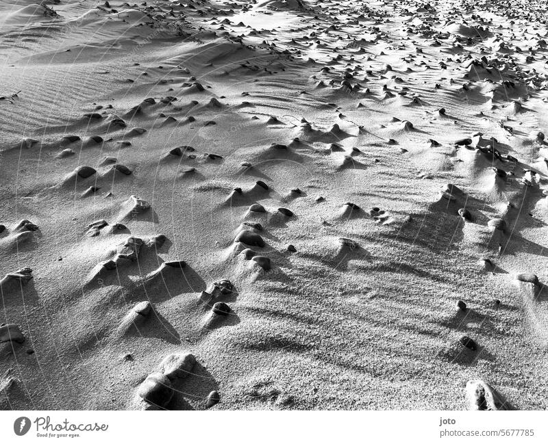 Steine am Strand in kontrastreicher Landschaft Sand Sandstrand Schatten Schattenspiel Kontrast surreal Außenaufnahme Küste Menschenleer Meer Sonnenlicht