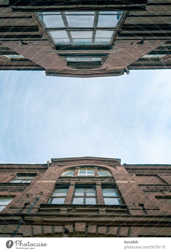 alte, alte Backsteinhäuser in einer Stadtstraße in der Ukraine donezk Verlassen Architektur blau Unteransicht Baustein Gebäude Großstadt Stadtbild Wolken Farbe