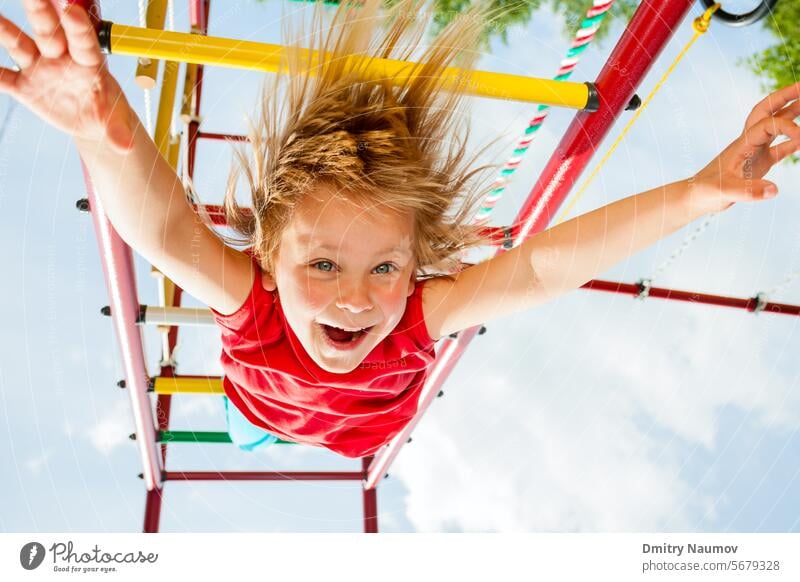 Kleines Mädchen hat Spaß beim Spielen auf dem Affengitter Aktivität Kaukasier heiter Kind Kindheit Aufstieg Klettergerüst niedlich Emotion genießen Übung