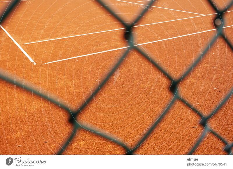 Blick auf einen leeren Tennisplatz durch Maschendrahtzaun hindurch Spielfeld Tennis spielen Tennisfeld Sandplatz Sport Sportstätten Sport treiben Blog