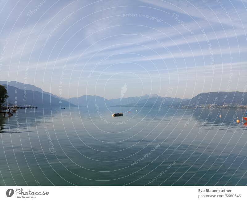 Ruhige Sommerstimmung mit Boot am Attersee bei Sonnenschein See Kondensstreifen Dunst Schafberg Berge Salzkammergut Spiegelung Landschaft Natur Österreich