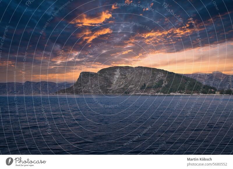 Westkappe in Norwegen. Ein Berg, der in den Fjord hineinreicht. Bewölkter Himmel mit Wolken Berge Küste Natur Wasser horizontal Fischen atlantisch Felsen Schnee