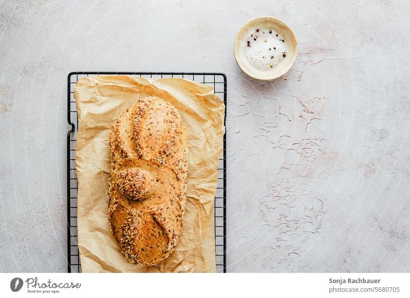 Ein Brotlaib und Salz auf einem Tisch. Draufsicht. Schüssel gebacken Frühstück selbstgemacht rustikal grau braun frisch Lebensmittel lecker geschmackvoll