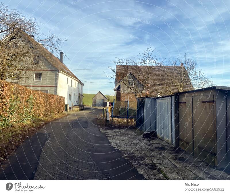 ländlich Dorf Haus Garage Schuppen Straße Architektur Gebäude gehöft Wohnsitz Wohngebäude Durchgangsstraße durchgangsverkehr Hecke Himmel ländliche Umgebung