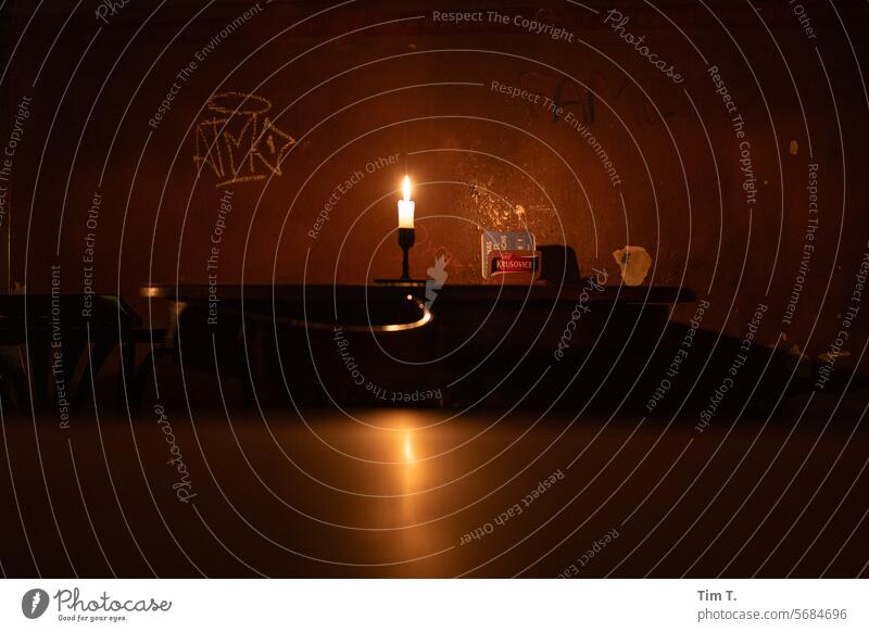 eine brennende Kerze in einer dunklen Kneipe Prenzlauer Berg dunkel Berlin leer Stadt Hauptstadt Stadtzentrum Menschenleer Altstadt Farbfoto Nacht