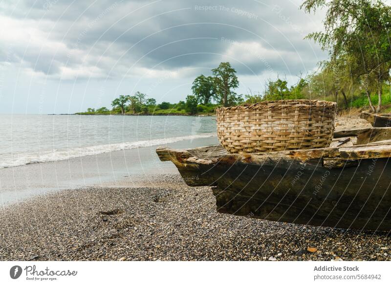 Korb auf dem Boot am ruhigen Strand von Praia Emilia praia emilia hölzern Bäume wolkig Himmel rustikal Ufer Kieselsteine Insel Natur Gelassenheit Meeresufer