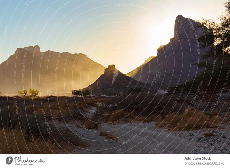 Sonnenuntergang über einer staubigen Berglandschaft Berge u. Gebirge Staubwischen Sonnenstrahlen Landschaft Natur guelta essendilene im Freien Abenddämmerung