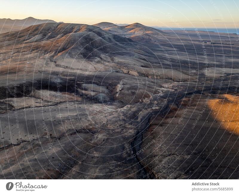 Das Licht der goldenen Stunde wirft Schatten auf die uralte Vulkanlandschaft an der Nordküste Fuerteventuras, in der Nähe von El Cotillo und Majanicho, bei Faro del Toston