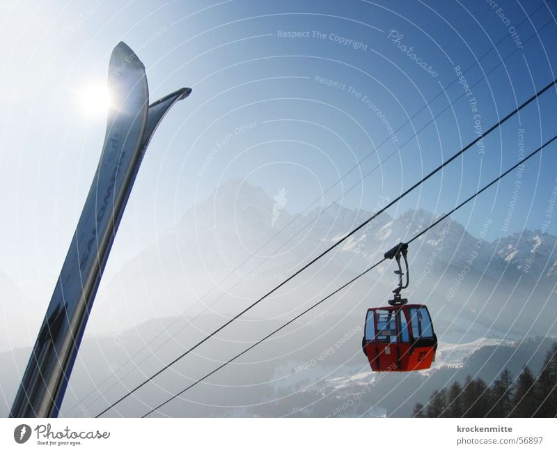 gipfeltreffen Winterurlaub Gegenlicht Skierspitze Drahtseil Bergkette Wintersport Gondellift aufwärts himmelwärts Sonnenlicht Dunst alpin diagonal Stahlkabel