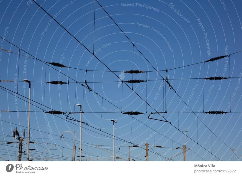 Elektrische Leitungen eines Bahnhofs Elektrokabel Stromleitungen Elektrizität Energie Transport Zug Blauer Himmel Energiewirtschaft Technik & Technologie