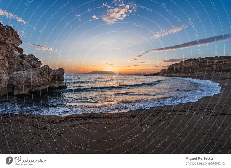 Playa Peñon del Cuervo, Strand in der Stadt Málaga mit einer Felsformation, die den Strand in zwei Teile teilt, im östlichen Teil der Stadt, Costa del Sol.