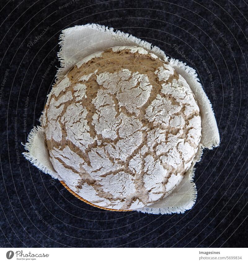 Selbstgebacken. 50% Weizen, 50% Roggen. Rundes Bauernbrot. Sauerteigbrot mit knuspriger Kruste auf dunklem Hintergrund. Backwaren. von oben. Quadratische Komposition