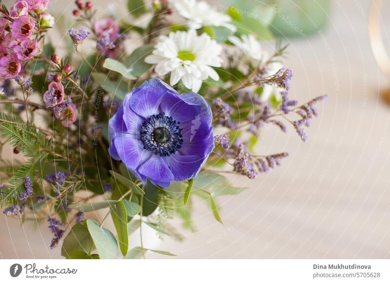 schönen Blumenstrauß mit lila Anemone und rosa Wachs Blume auf weiß beige neutralen Hintergrund Nahaufnahme Kopie Raum rechts. Blumenarrangement vertikale Kulisse.