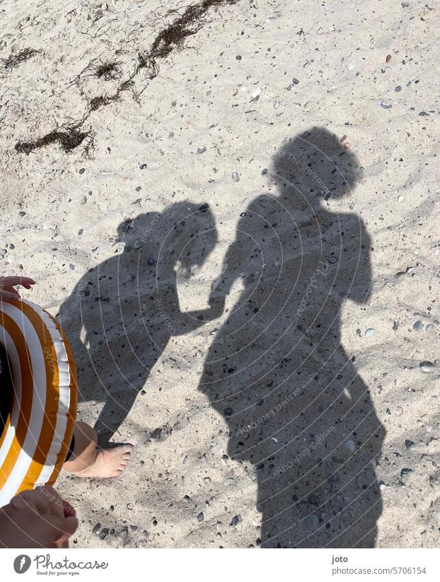 Mutter und Kind als Schatten auf dem Sand am Strand beim Baden Silhouette Mutterschaft mutter und kind zwei Menschen Hand halten Zusammensein Glück Kindheit