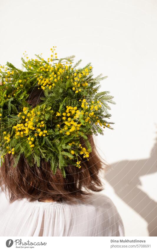 weibliche Floristin hält schönen Blumenstrauß mit gelben Mimosen Frühlingsblumen, Ranunkeln und Eukalyptusblätter. Frische elegante Wohnkultur. Florist Arbeit.