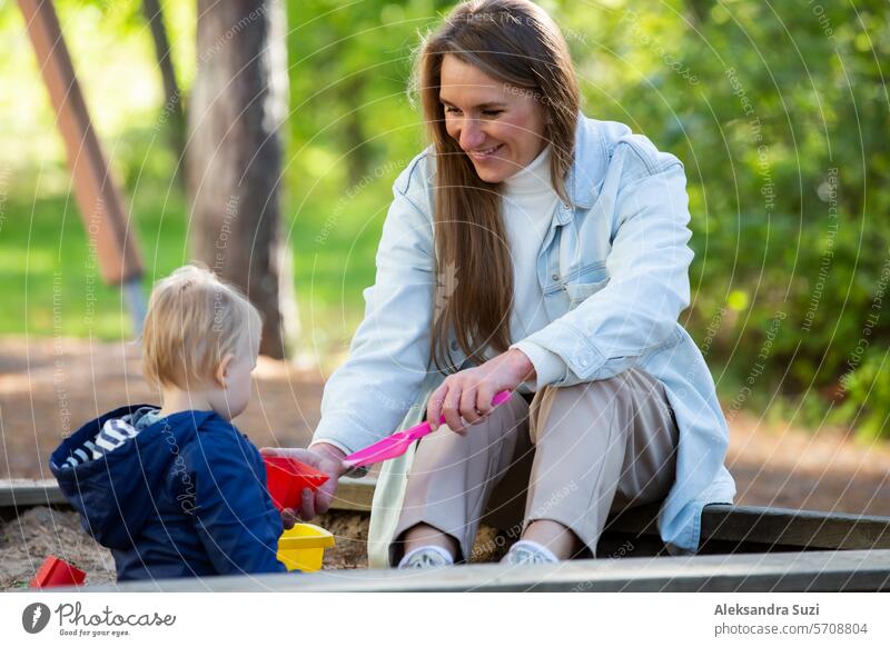 Die Mutter mit zwei Kindern vergnügt sich auf dem Spielplatz. Zwei kleine Jungen mit ihrer Mutter spielen im Sandkasten aktiv Aktivität Pflege lässig Kaukasier