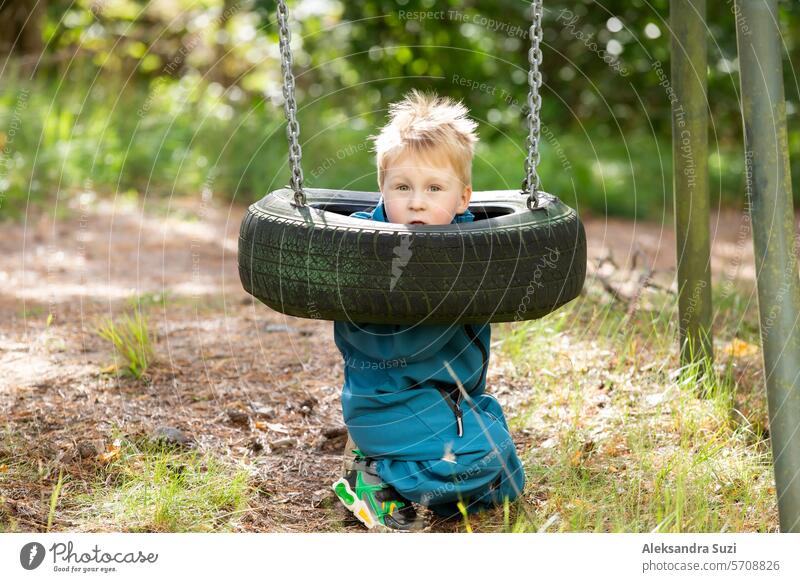 Ein kleiner Junge spielt auf dem Spielplatz. aktiv Aktivität Erwachsener Baby schön Pflege Kaukasier Kind Kindheit Kindertag niedlich Tag Familie Spaß Garten