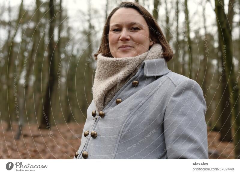 seitliches Portrait einer jungen Frau im Wald beim Spaziergang, sie lacht in die Kamera junge Frau Waldspaziergang spazieren gehen Erholung lachen Freude Spaß