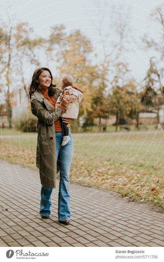 Junge Frau hält süßes Baby Mädchen im Herbst Park klein Kaukasier Mutter außerhalb Tochter Kind wenig Liebe niedlich Beteiligung Fröhlichkeit Zusammensein