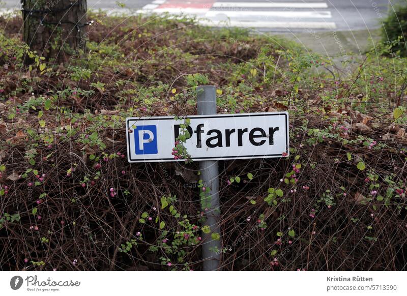 parkplatz vom pfarrer kennzeichen stellplatz autokennzeichen parken reserviert reservierung sonderstellung schild markierung bepflanzung grünanlage sträucher