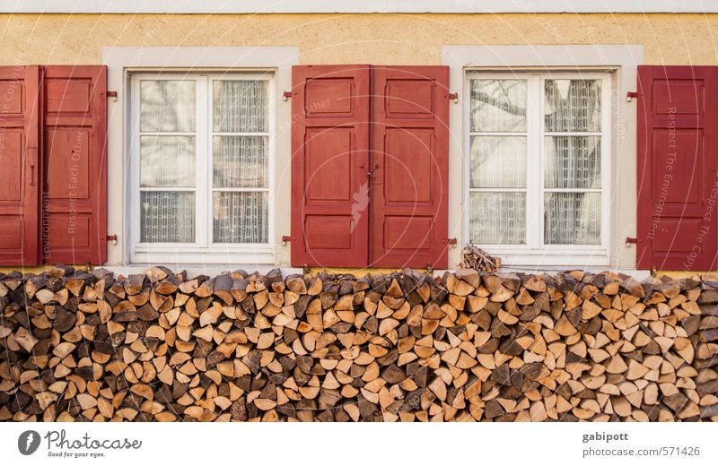 mal wieder richtig einheizen Winter Dorf Haus Hütte Fassade Fenster Holzstapel Freundlichkeit gelb rot Geborgenheit Warmherzigkeit Romantik Häusliches Leben