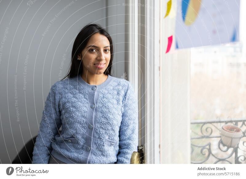 Junge Frau lächelnd in der Nähe des Fensters im Tageslicht jung Lächeln lässig heiter Stimmung blau Pullover Stehen post-it Notizen hell sanft Erwachsener