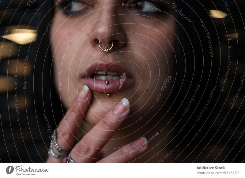 Nahaufnahme einer nachdenklichen Frau mit Piercings im städtischen Madrid Gedanke Nasenring Lippenring urban four towers business area jung besinnlich