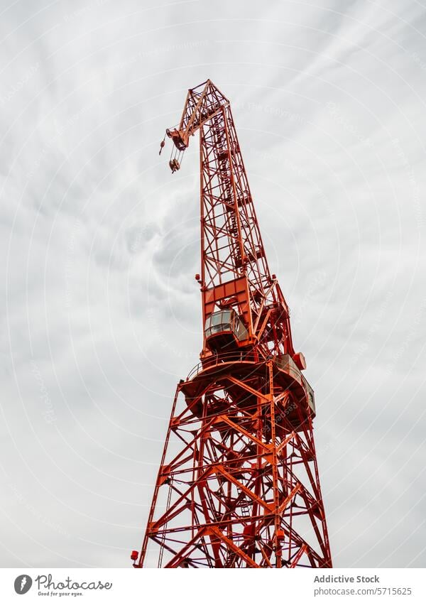 Roter Baukran vor einem bewölkten Himmel im Hintergrund Kranich Konstruktion rot wolkig industriell Struktur Gebäude Entwicklung turmhoch Maschine Gerät