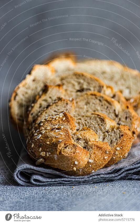 Nahaufnahme von frisch geschnittenem Sauerteigbrot mit Samen auf einem strukturierten grauen Tuch Hintergrund Brot Scheibe Textur Vollkorn Kunstgewerbler