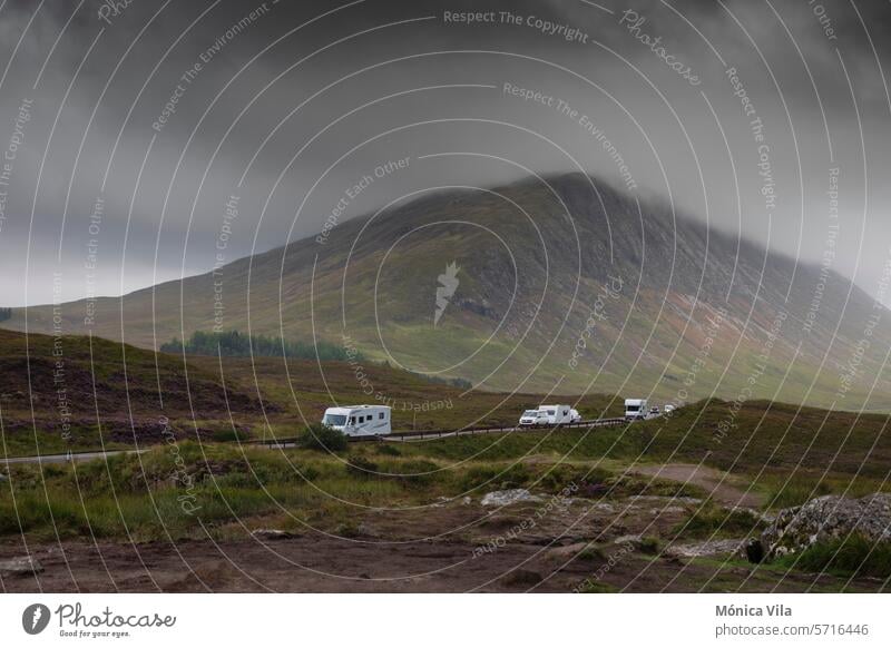 Wohnmobile und Wohnwagen auf der A82 in den Glencoe Mountains an einem Tag mit dramatischem Himmel vom Glencoe Lookout aus Berge Aussichtspunkt Glencoe