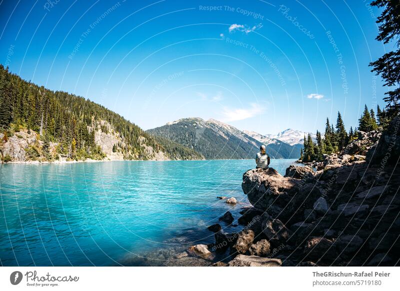 Frau Sitzt auf einem Stein neben dem See und schaut in die Weite Kanada Wald Berge u. Gebirge aussicht wandern Baum Panorama (Aussicht) Blauer Himmel sonnig