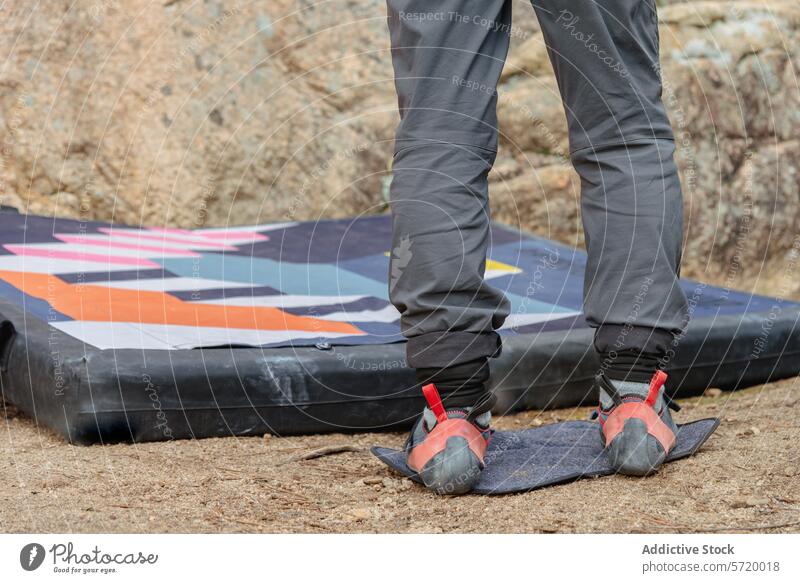 Ein anonymer Kletterer steht auf einem Crashpad, bereit, den Boulder zu bezwingen, und präsentiert die speziellen Kletterschuhe Aufsteiger Fuß Sturzpad Bouldern