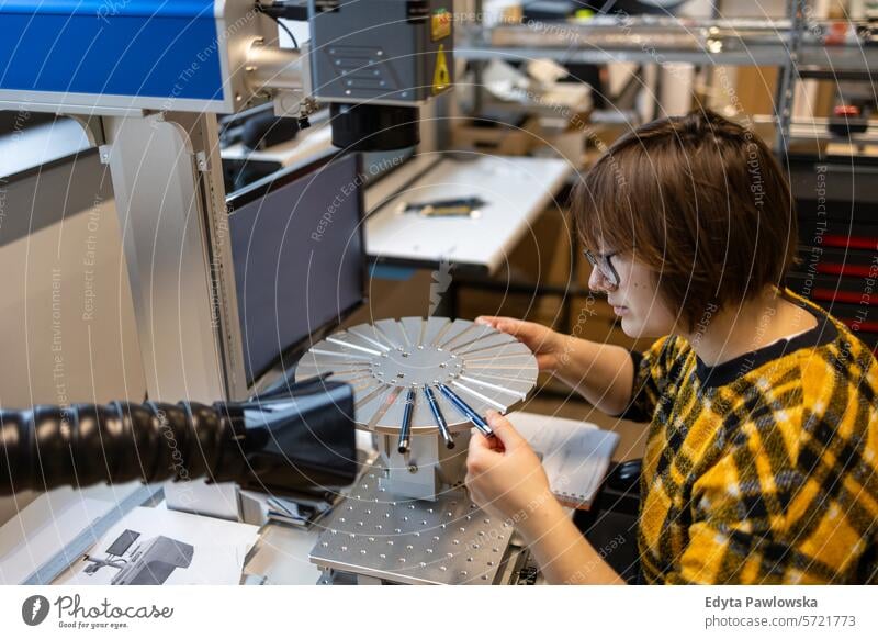 Frau bedient eine Maschine, die Logos auf Stifte druckt Business Mitarbeiter Fabrik industriell Industrie Job Güterverkehr & Logistik Herstellung Beruf Menschen