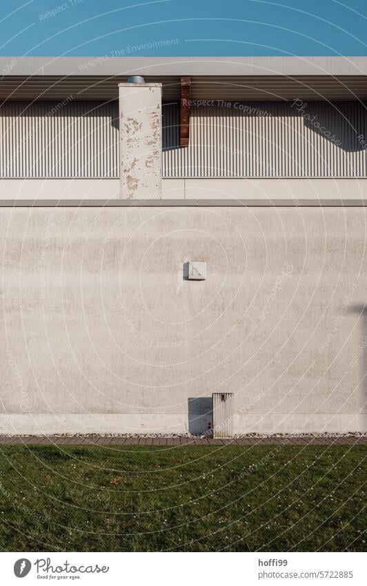 Betonfassade zwischen Himmel und Wiese Betonwand Himmelsstreifen Rasen Blauer Himmel Sichtbeton Gras Architektur grün Fassade blau Mauer Strukturen & Formen