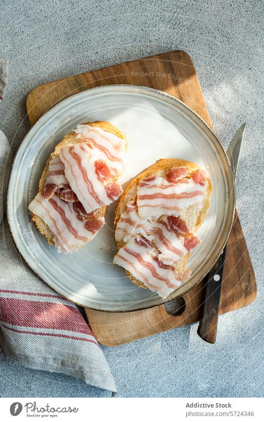 Toasts mit Schmalzscheiben auf Holzbrettchen Zuprosten Speck Scheibe hölzern Schneidebrett rustikal Frühstück Messer Teller Nahaufnahme Lebensmittel