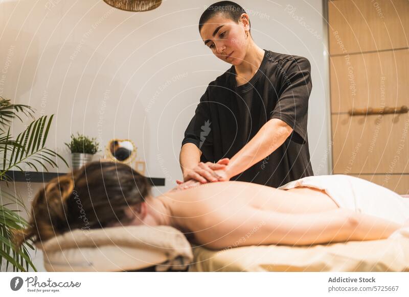 Therapeutin bei einer entspannenden Rückenmassage im Spa Massage Wellness Erholung Klient Gesundheit Therapie Behandlung Pflege beruhigend kompetent friedlich