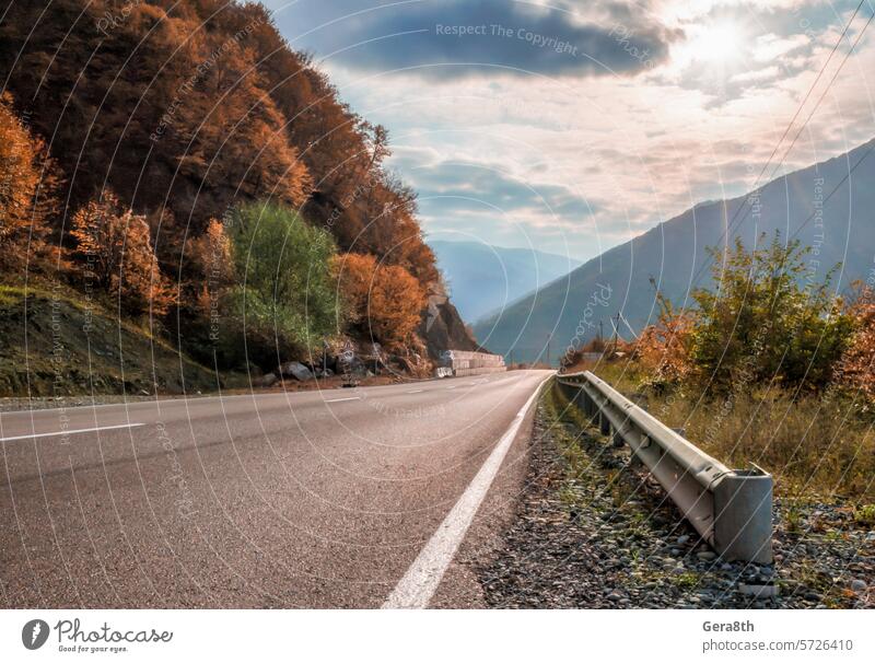 Bergstraße und Himmel mit Sonnenstrahlen in Georgien Kaukasus Sakartwell Asphalt Herbst Wolken Tag Menschenleer Hügel Landschaft Licht Berge u. Gebirge Natur