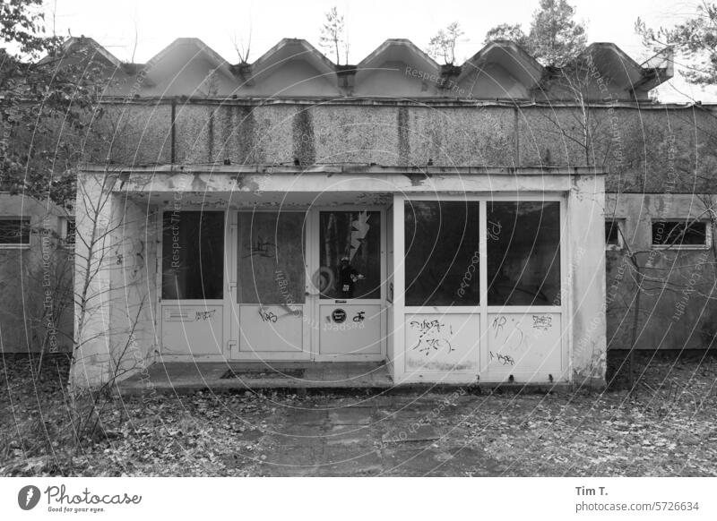 ein alter Eingang zu einem Gebäude mit DDR Architektur Ruine Brandenburg s/w Winter Schwarzweißfoto Menschenleer Tag Außenaufnahme b/w b&w ruhig Einsamkeit