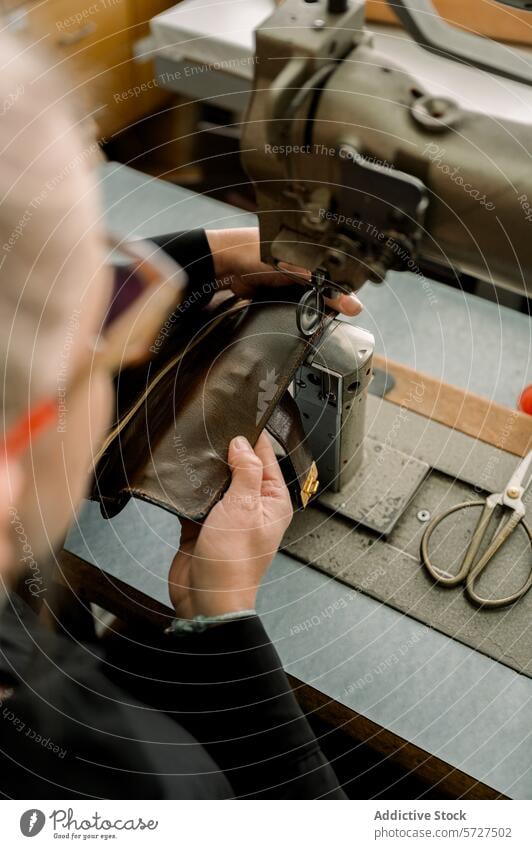 Schuhmacher bei der Arbeit in einer österreichischen Werkstatt Schuster Österreich Handwerk Leder Reparatur Nähmaschine Handwerkskunst traditionell manuell