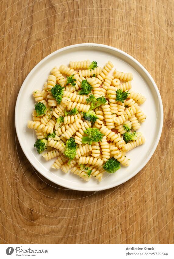 Draufsicht auf ein köstliches Gericht mit Fusilli-Nudeln und leuchtend grünen Brokkoliröschen, präsentiert auf einem weißen Teller Spiralnudel Spätzle Röschen