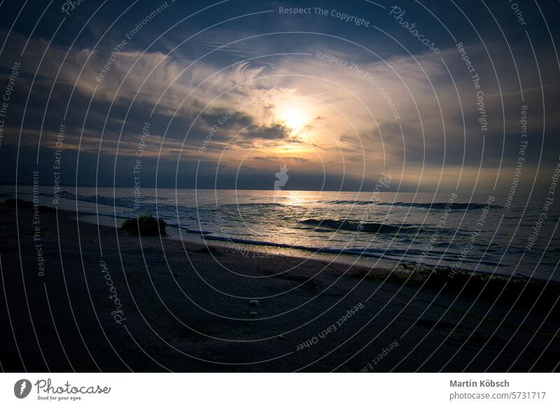 Sonnenuntergang, beleuchtetes Meer. Sandstrand im Vordergrund. Leichte Wellen. Ostsee Sonnenstrahlen Sonnenschein Reflexion & Spiegelung Küste winken reisen